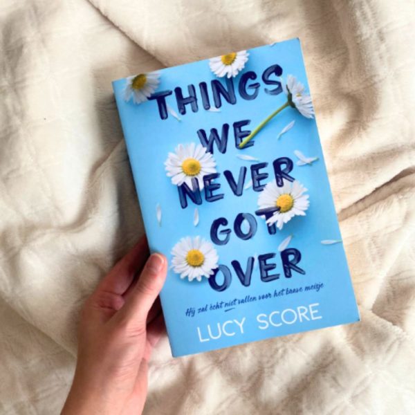 A hand holding Things We Never Got Over by Lucy Score