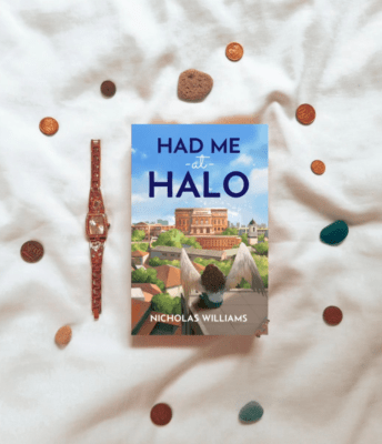 The cover of Had me at Halo surrounded by colourful pebbles and a watch