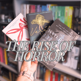 a hand holding three books in front of a blurry shelf with a title overwritten saying 'The Rise of Horror'