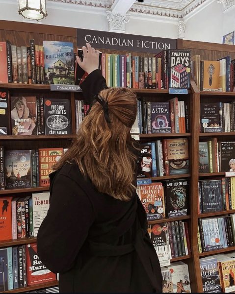 a woman with her back to us browsing book shelves