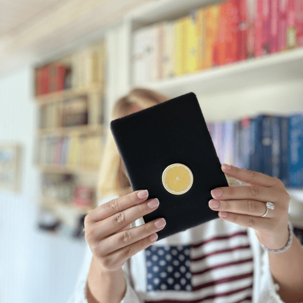 a woman with a kindle in front of her face